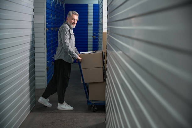 istock Male carrying large trolley filled with stacked boxes 2162417561