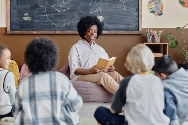 istock Woman Reading Book to Students at Primary School 2162419655
