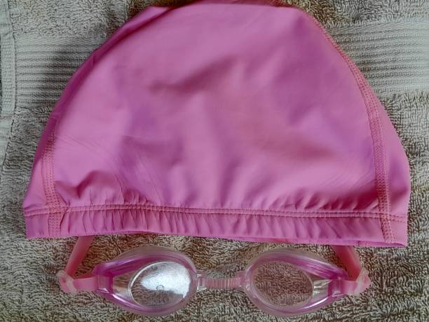 Swimming suit kit. Hat,  goggles and body on blue studio background