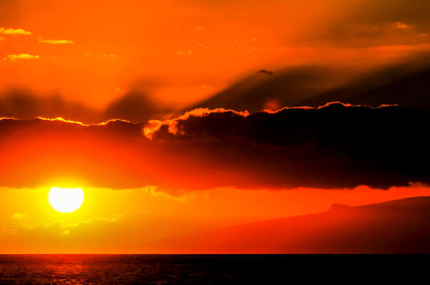 istock The sun is setting over the ocean, casting a warm orange glow over the water 2162431136