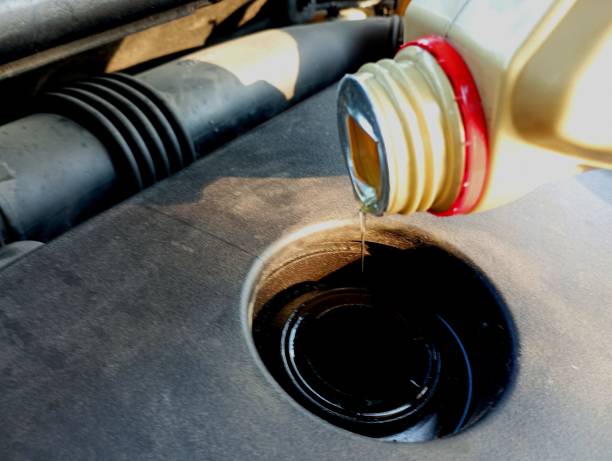 istock Adding engine oil to the engine. The process of adding lubricant through the neck from a plastic bottle for lubricating engine parts. 2162435443