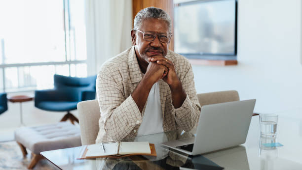 istock Successful and confident senior man working at home with a laptop and notebook 2162443913