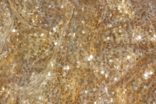 istock Gold sequin background with white silk folds on top. 2162445822
