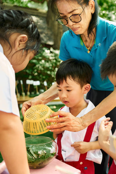 istock Elementary students examine insect with teacher in outdoor science lesson 2162447041