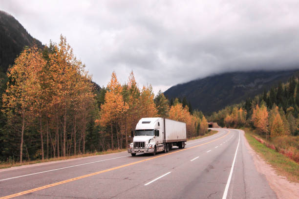 Semi truck trailer on the road in the fall