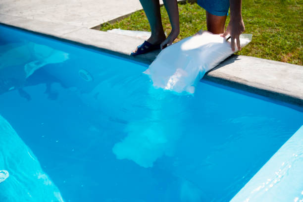 istock Worker Pour salt into the pool - swimming pool keeping clean 2162449474