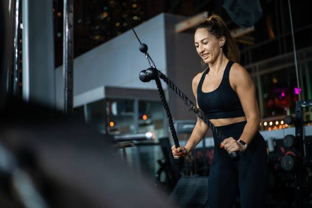istock Woman Doing Cable Rope Bicep Curls In Gym During Workout 2162450397
