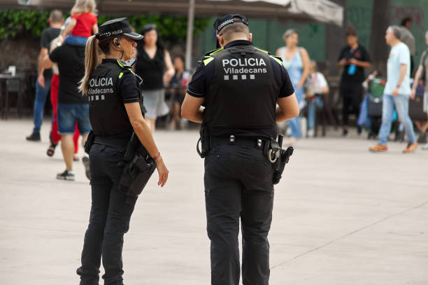 Police patrol on duty in Viladecans, Spain Viladecasn, SPAIN - JULY 17, 2024: Two local police officers from Viladecans patrol a busy public area, providing security and surveillance in their community. Their presence is a reminder of the ongoing commitment to law and order. police policewoman women spain stock pictures, royalty-free photos & images