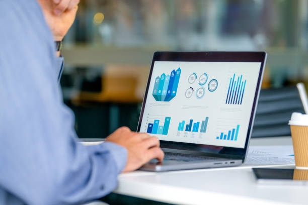 istock Close up of businessman using a laptop with graphs and charts on a laptop computer. 2162455754