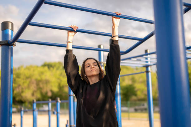 istock Woman Doing sport Pull-Ups on Monkey Bars at Outdoor Gym 2162457583