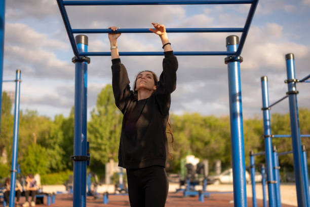 istock Woman Doing sport Pull-Ups on Monkey Bars at Outdoor Gym 2162457596