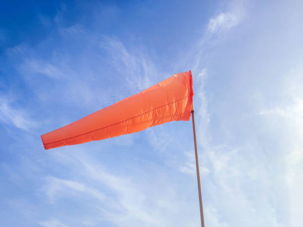 istock orange windsock against a bright blue sky background. serves to determine the wind direction 2162460070