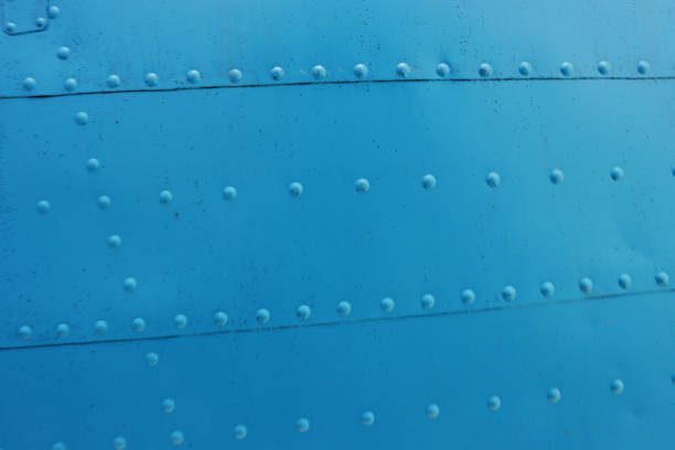 Blue Surface of a metal wall with rivets close-up.