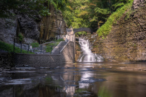 istock Hiking path and stairs leading to a beautiful cascading waterfall surrounded by lush greenery. Cascadilla Gorge in Ithaca New York 2162463056