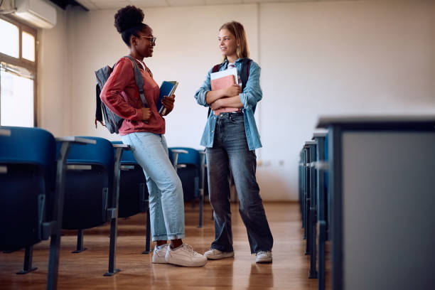 istock Happy female college students communicating after a class in lecture hall. 2162463101