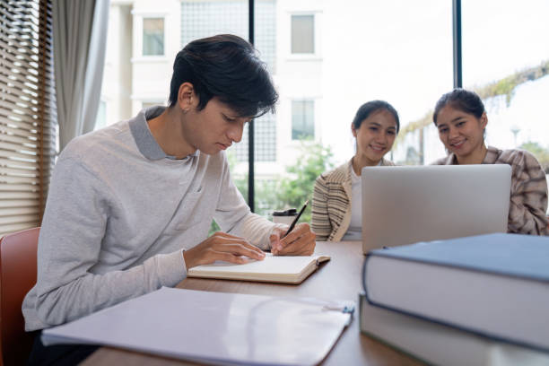 istock Group of Student Studying Together in a Modern Library with Laptops and Notebooks 2162473029
