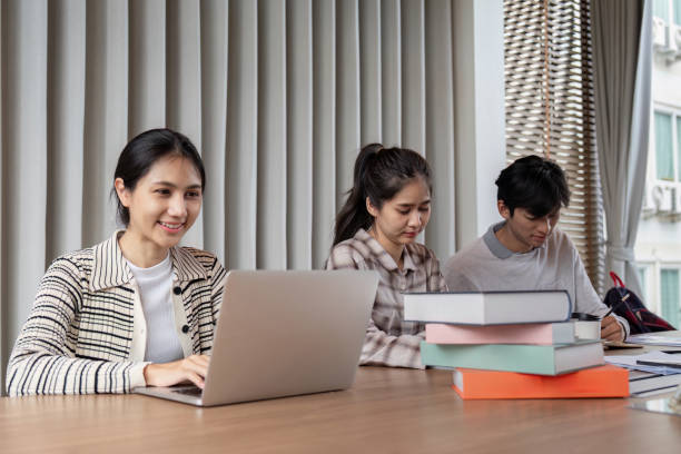 istock Group of Focused Student Study Together with Laptops and Books in a Modern Classroom Setting 2162473321