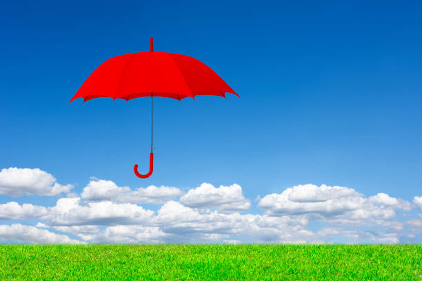 istock Red umbrella in mid-air against blue sky 2162474767