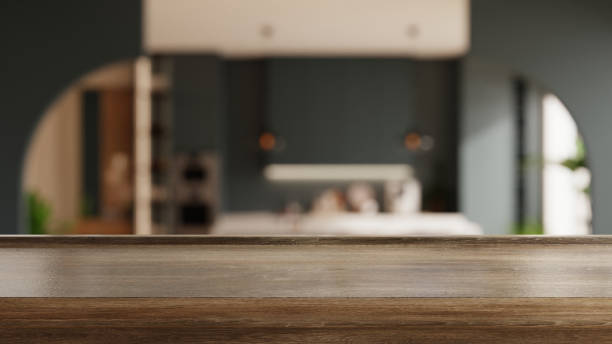 Wooden table top on blur kitchen room background, showcasing a modern and sleek kitchen design with dark cabinetry- 3D rendering