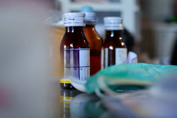 Medical medicines in bottles, medical prescriptions, glasses on the table in the doctor's office. Old medical, pharmaceutical, apothecary, chemist's shop and scientific background.