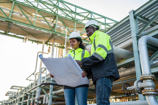 istock Young mechanical engineer holding blueprint drawing to checking. 2162483064