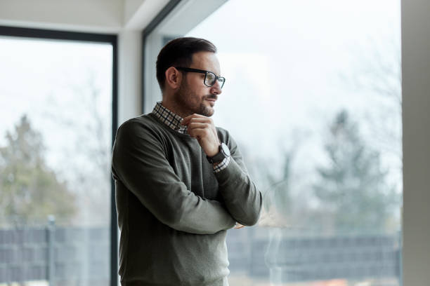 Carefree man day dreaming by the window.