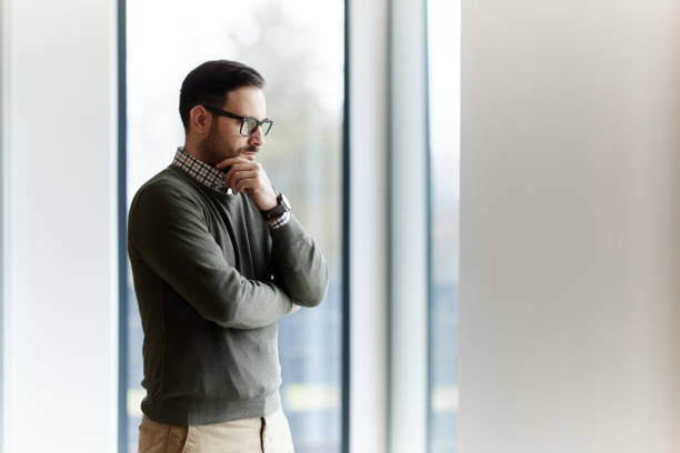 istock Thoughtful man brainstorming by the window. 2162490362