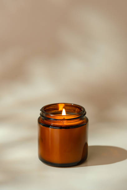 istock Candles in Glass Jars on a Light Beige Surface 2162490529