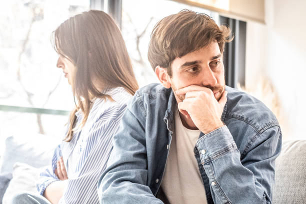 istock Engaged couple with relationship problems sitting on the sofa with their backs to each other after an argument, conflicts in marriage, upset couple after a dispute, making decision to break up and divorce 2162491315