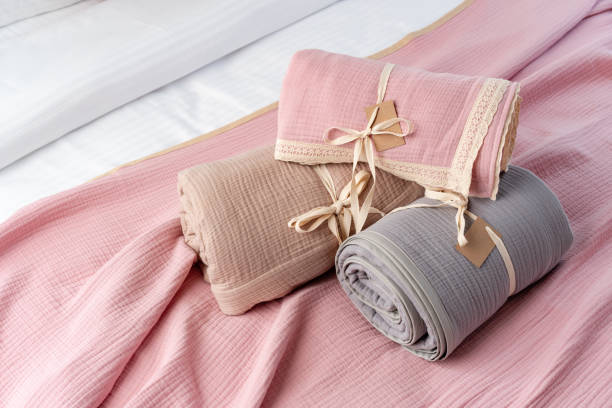 istock Rolled Up Soft Pink and Grey Muslin Blankets on Bed 2162492702