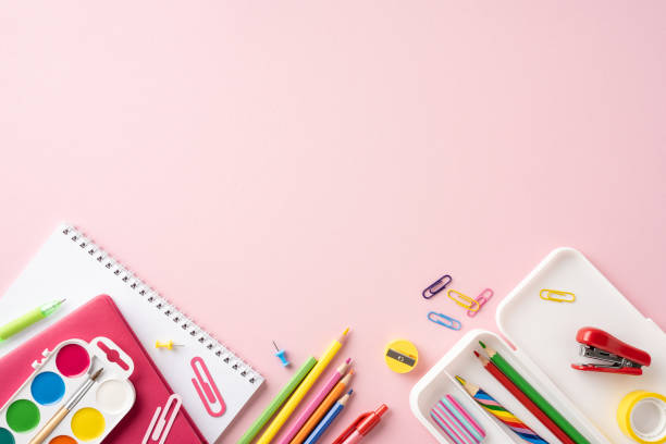 istock Colorful back to school stationery arranged on a pink background. Includes notebooks, pens, pencils, paper clips, and art supplies 2162502426
