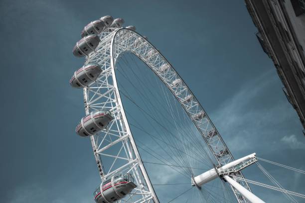 A low angle view of the London Eye, a giant Ferris wheel against a blue sky. London, UK - October 09, 2023 : A low angle view of the London Eye, a giant Ferris wheel against a blue sky. the shard close up stock pictures, royalty-free photos & images