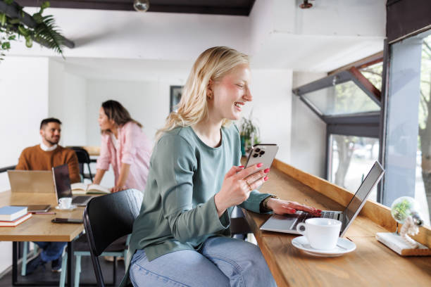 istock A smiling woman using a mobile phone in a hybrid office space 2162506070