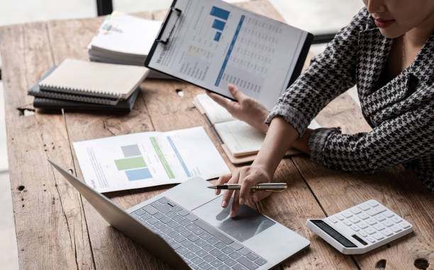 istock Young Accountant Analyzing Financial Documents and Data on Laptop at Wooden Desk in Modern Office Environment 2162507556