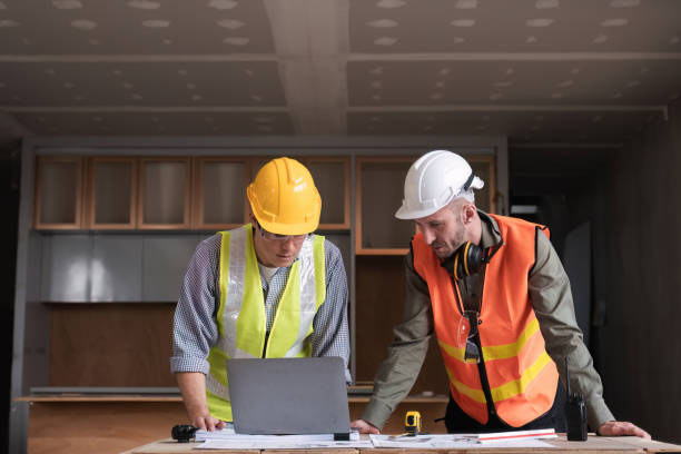 istock Engineering Team Collaborates on Work Plan at Construction Site with Safety Gear and Blueprints 2162507850