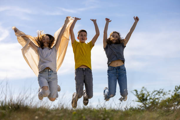 Three happy teenagers jumping in nature