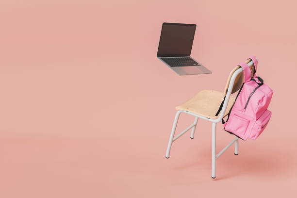 istock Pink Backpack and Laptop on Chair Floating in Minimalist Indoor Setting 2162510116