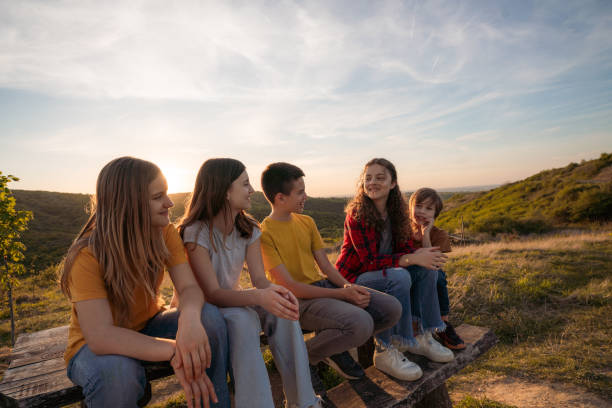 istock Group of children sitting and talking on the bench 2162511266