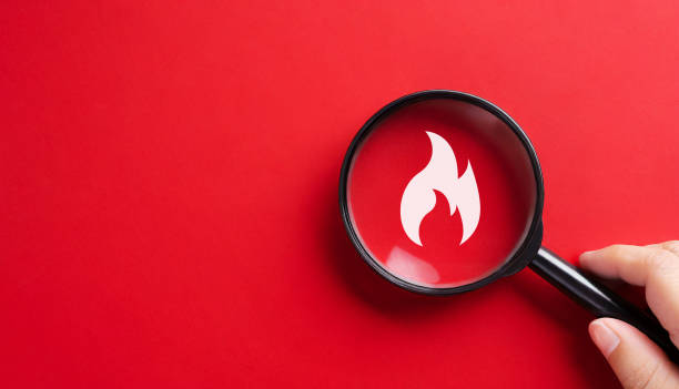 Magnifying glass with flame icon. Fire surveillance inspection and fire fighting concept.
