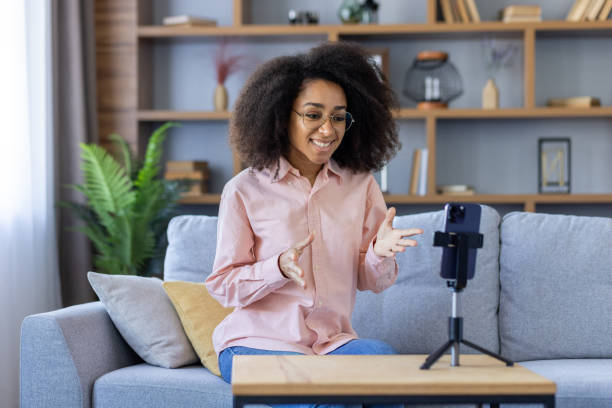 istock Woman having online video call on smartphone at home while sitting on sofa 2162513670