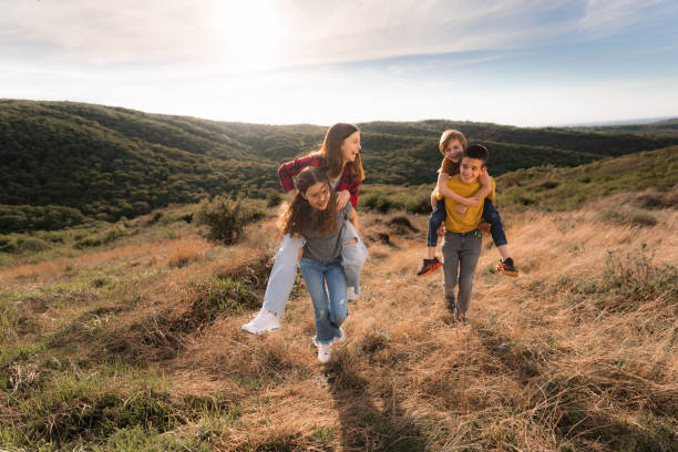 istock Boys and girl having fun while piggy back in nature 2162517838