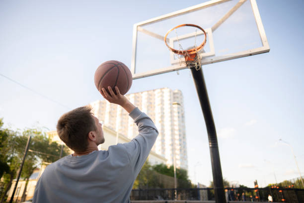istock concentrated young man doing basketball workout outdoors, dribble and shooting drill 2162518527