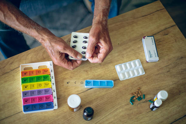 istock Senior man sorting pills into medical pill boxes 2162518780