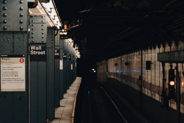 istock Wall street sign in empty subway with blue light reflecting from tracks 2162519110