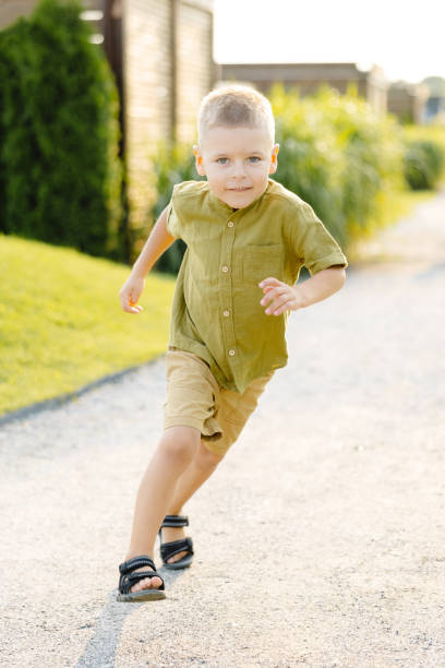 istock A Young Boy Joyfully Sprinting Down a Dusty Gravel Path on a Scorching Summer Day, His Laughter Echoing Through the Air 2162519919