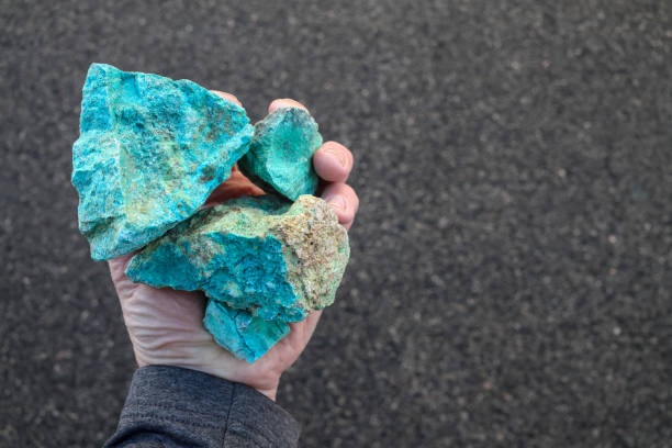 istock Blue green copper (Cu) oxide ore, held in hand. Mining. 2162525064