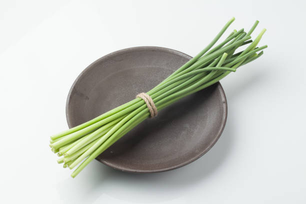 Chive blossoms add a touch of purple to a city garden