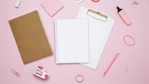 istock Creative flat lay mockup design of workspace. Top view composition with white notebook, to do list and stationery on pink background 2162526356