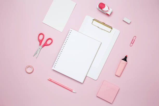 istock Creative flat lay mockup design of workspace. Top view composition with white notebook, to do list and stationery on pink background 2162526359