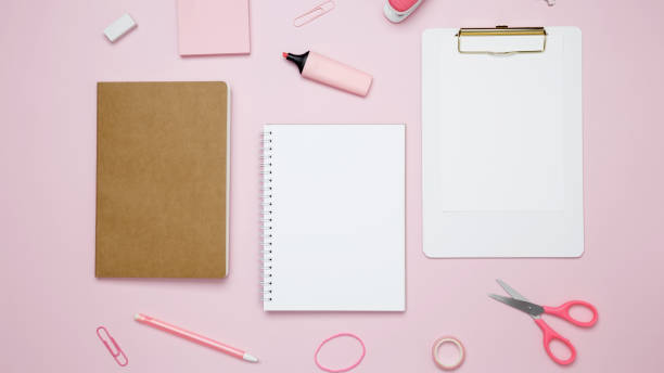 istock Creative flat lay mockup design of workspace. Top view composition with white notebook, to do list and stationery on pink background 2162526366